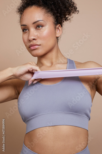 Studio portrait of athletic woman exercising with resistance band © Cultura Creative