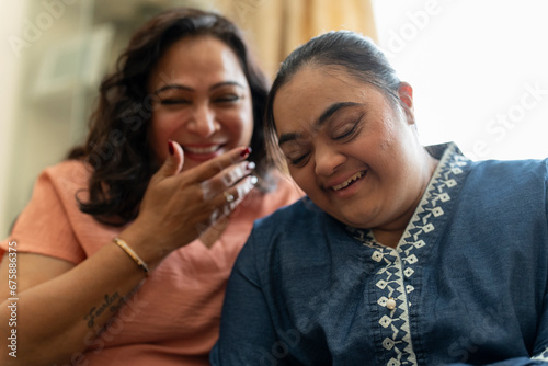 Portrait of woman with down syndrome daughter laughing at home