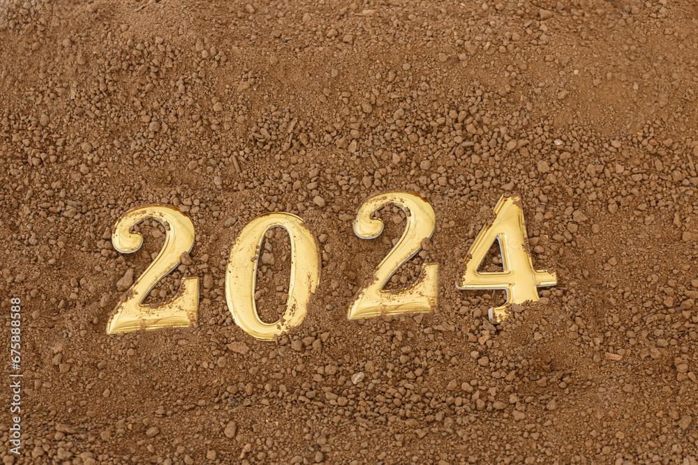 Fototapeta premium Happy New Year concept. Gold text 2024 number on floor soil surfaces