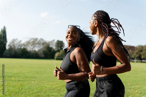 Young female friends jogging in park photo