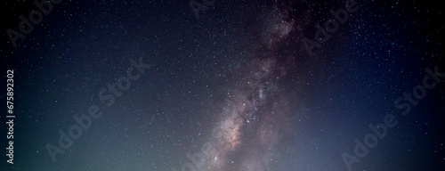 Panorama blue night sky milky way and star on dark background.Universe filled with stars, nebula and galaxy with noise and grain.Photo by long exposure and select white balance. photo