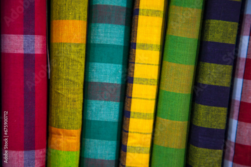 Multicolor Traditional Bangladeshi men's wear lungi folded on a rack in a store. Can be used as pattern texture background wallpaper