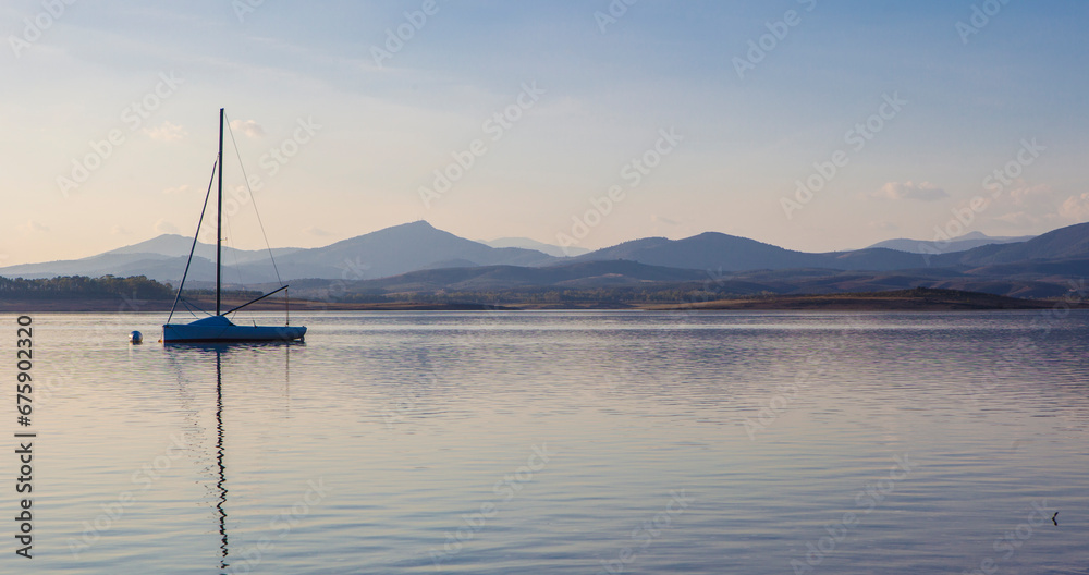 Sailing boat anchored on the shore of the Gabriel y Galan reservoir