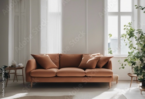 Close-up of fabric sofa with terra cotta pillow against the window and white wall Scandinavian home interior