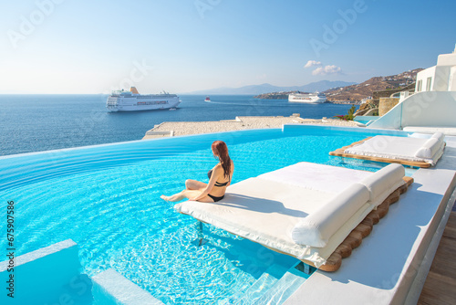 Tourist enjoys at infinity pool with sea view, Mykonos, Greece