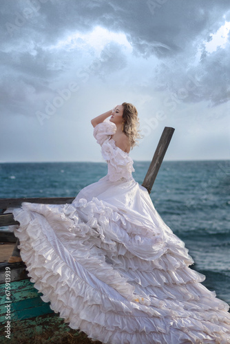 happy mysterious woman silhouette mermaid long black hair walks beach blue water of ocean, sea nymph wind listening wave. long blue dress flying train, look divine sunset. Art photo from back no face