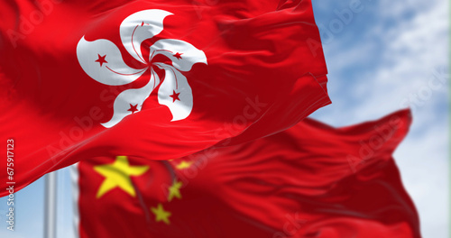 Flags of Hong Kong and China waving in the wind on a clear day photo