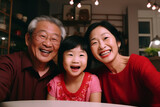 Asian multi generation family, grand father, mother and little little daughter smiling to camera.