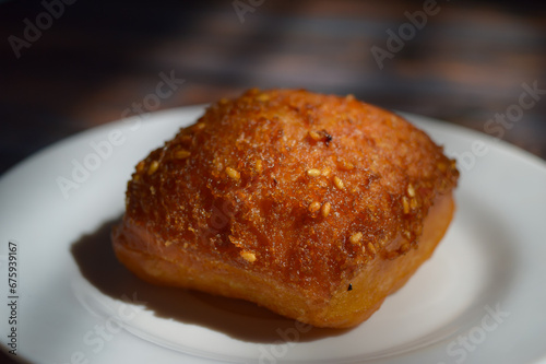 Odading or cube-shaped fried bread with a brown crispy outer skin and sprinkled with sesame seeds, the inside is empty and expands, so that it looks like a small pillow.