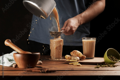 Canvas Print A man pours a traditional Indian drink, masala chai.