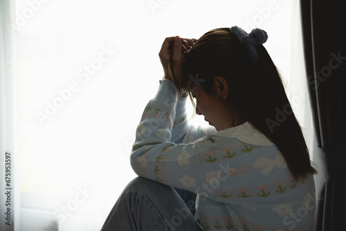 Silhouette depressed woman sadly sitting on the bed in the bedroom. Sad asian women suffering depression insomnia awake and sit alone on the bed in bedroom. Depression health people concept.