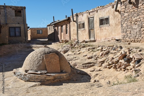 Traditional horno, or bread baking oven, with adobe buildings behind. photo