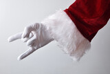 Santa Claus making horns wearing gloves and traditionally dressed