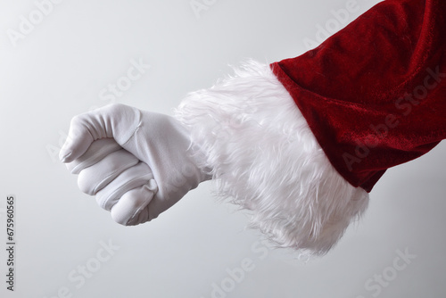 Santa Claus hand with clenched fist wearing gloves dressed traditionally