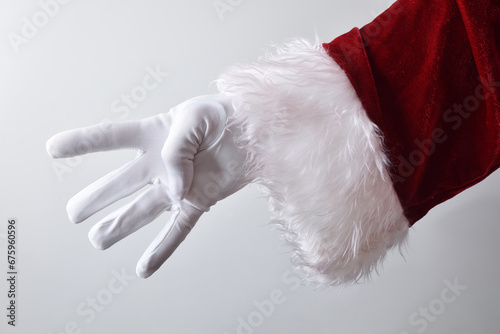 Santa Claus hand showing four fingers wearing gloves dressed traditionally