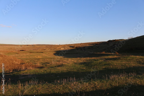 A grassy field with a hill in the background