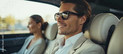 The successful businesswoman traveled with her family in a luxurious white car enjoying the window view while the man and woman couple in glasses were attending a teacher s presentation on  photo