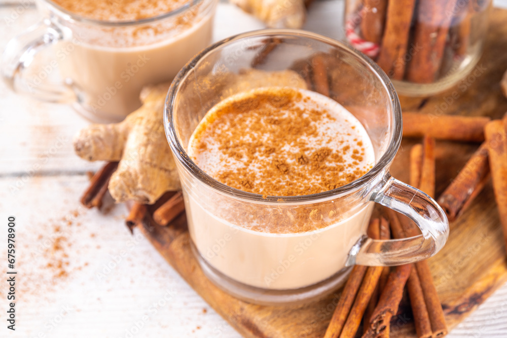 Cinnamon Stick sore throat tea with milk, with ginger and coconut non-dairy milk, on white wooden kitchen table, copy space Cinnamon Stick sore throat tea with milk, with ginger and coconut non-dairy milk, on white wooden kitchen table, copy space