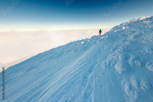 Climber in the mountains. A girl walks through the snow in the mountains.