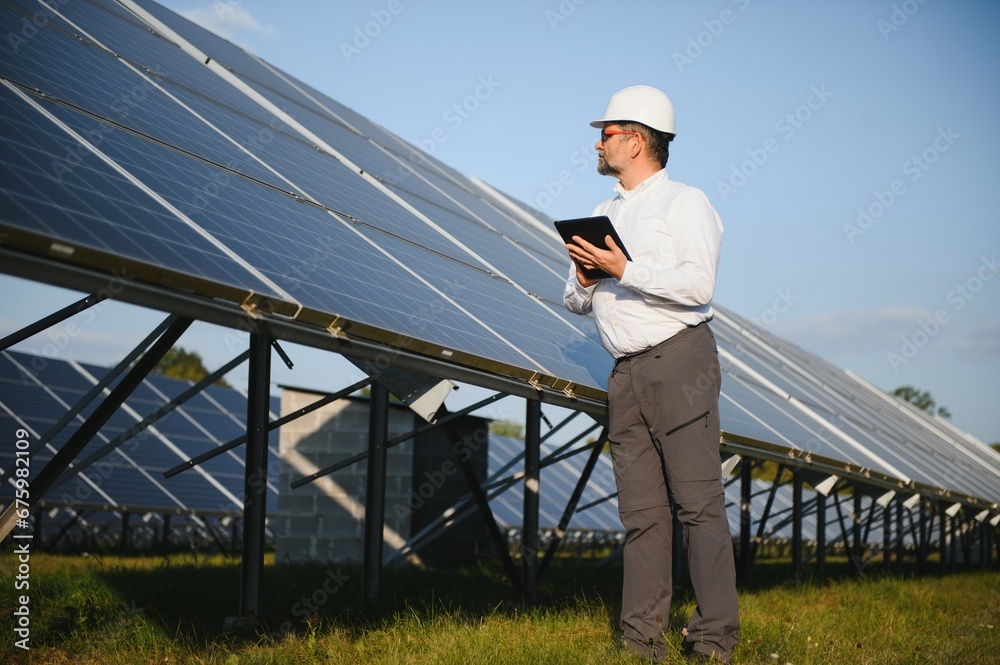 Senior engineer working on solar panel farm. The concept of green energy Senior engineer working on solar panel farm. The concept of green energy
