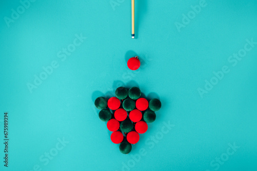 Konstfotografi Creative Christmas tree made from red and green velvet Christmas balls and billiard cue on a turquoise background like pool table