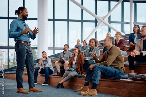 Принти на полотні Black businessman talks to large group of entrepreneurs during education event in conference hall