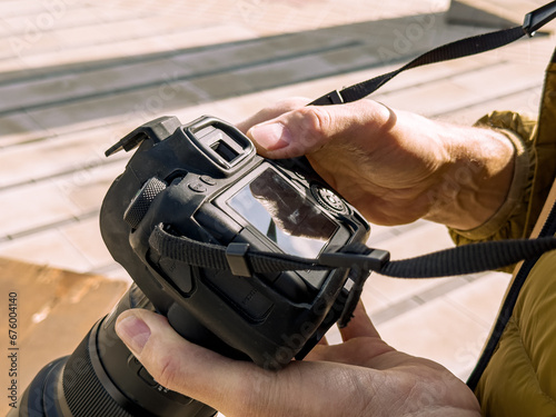 Hands holding photo camera, adjusting for shooting photo