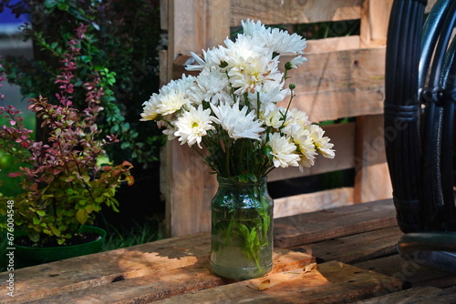 White flowers in a glass vase in the garden