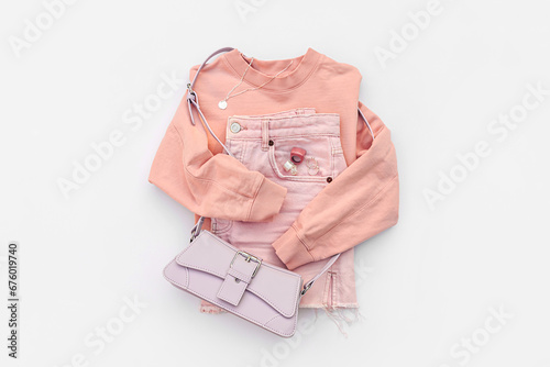 Fashion spring or summer outfit. Pink jumper and jeans with handbag. Women's stylish and elegant clothes with accessory and jewelry. Fashionable look. Flat lay, top view, overhead.