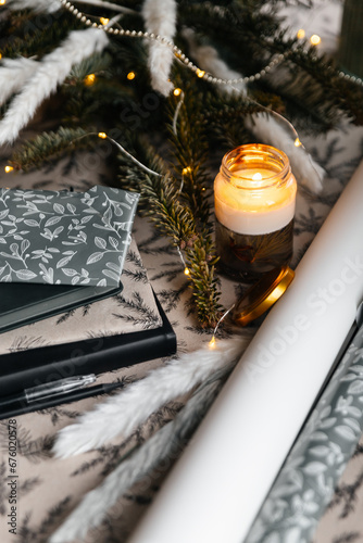 Festive christmas layout of decor, journals and a candle.