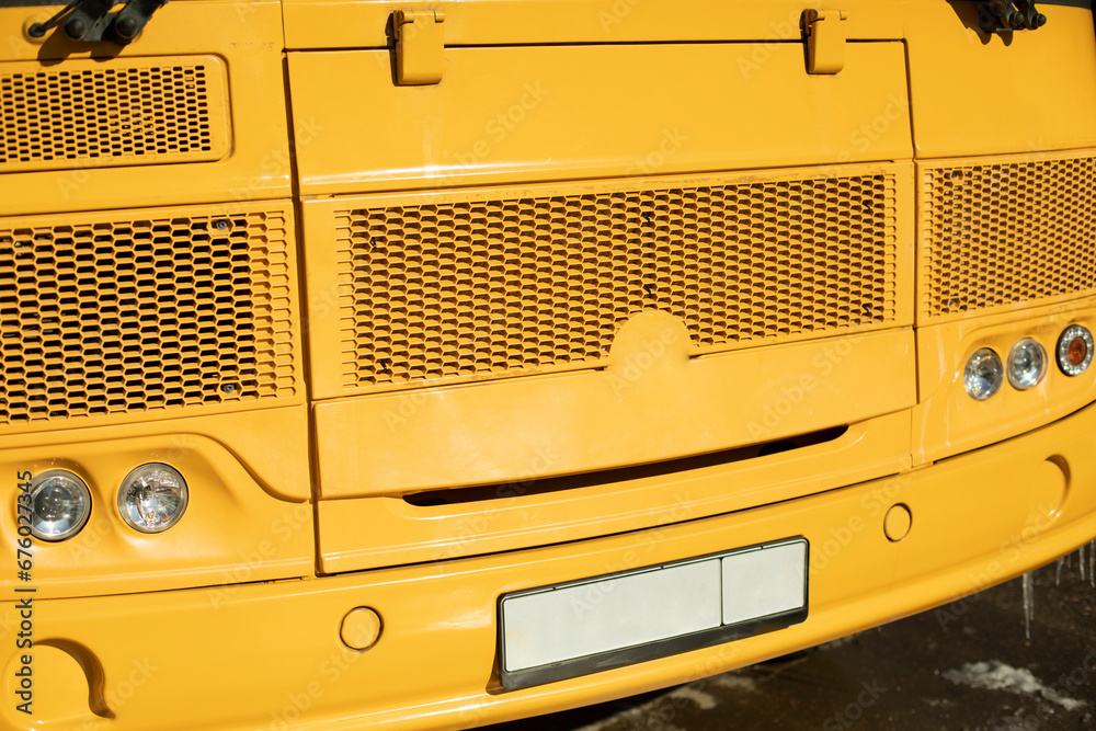 Yellow school bus. Details of school transport. Car headlights.