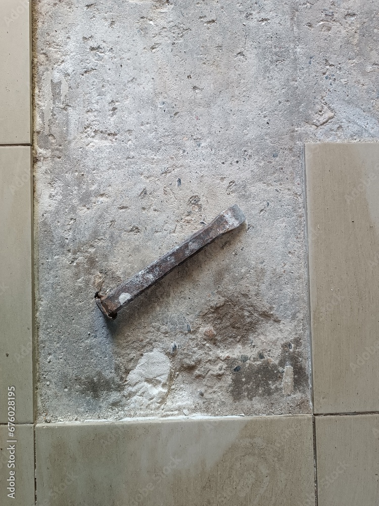 Floor tile removal. Old tools on floor. Dismantling old floor tiles