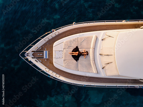 Fotografija Aerial View of Woman Relaxing on Luxury Yacht Over Turquoise Sea