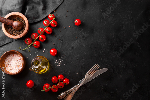 Food background, spices, tomatoes and oil on a black background, free space for text
