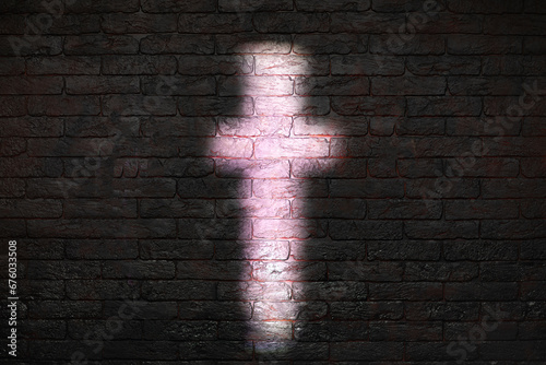 silhouette of a Catholic Cross on a brick wall
