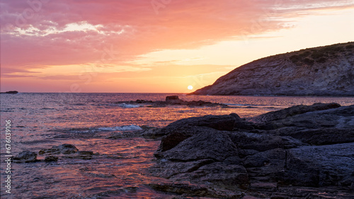 Sonnenuntergang an einem Strand in Sardinien mit Blick auf das Meer und den erleuchteten Himmel