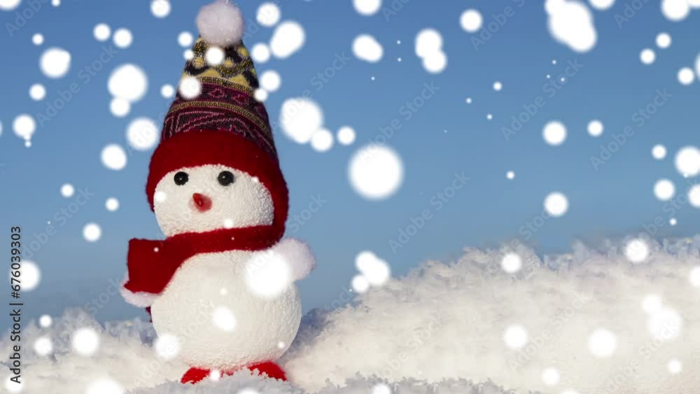 A snowman toy on the snow in a snowfall. Christmas, winter A snowman toy on the snow in a snowfall. Christmas, winter