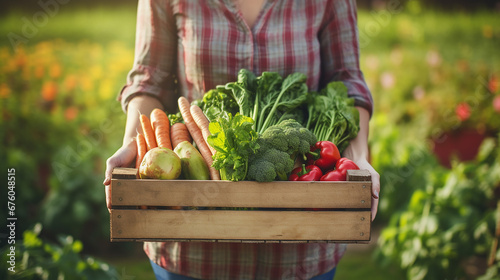 A farmer proudly displays a box of freshly harvested vegetables from her sustainable and environmentally friendly garden, the benefits of fresh and seasonal food