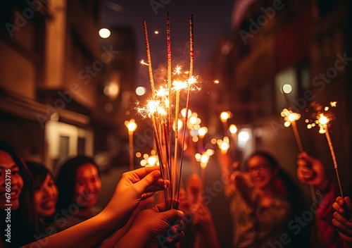 Group of happy people holding sparklers at party. New Year