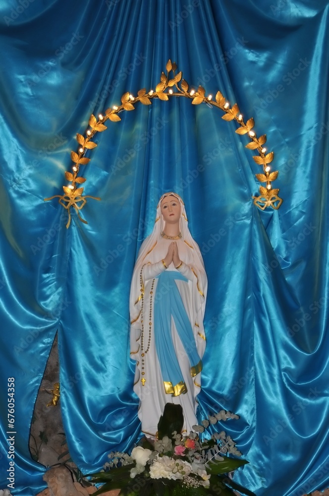 The blessed Virgin Mary statue figure. Catholic praying for our lady - The Virgin Mary. Blue linen copy space on background