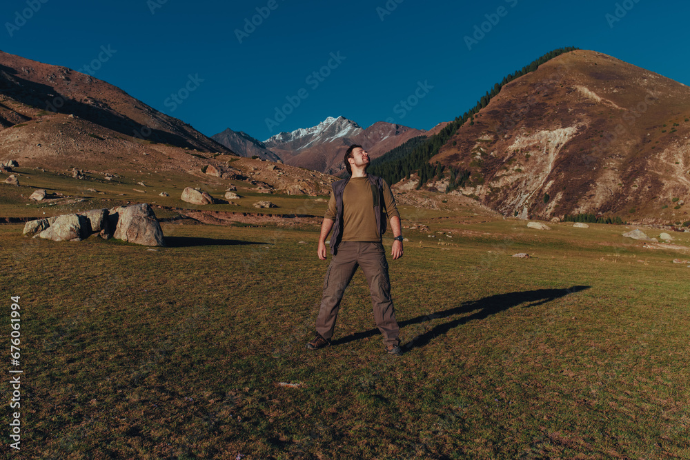 Fototapeta premium Happy young man tourist in the mountains in autumn