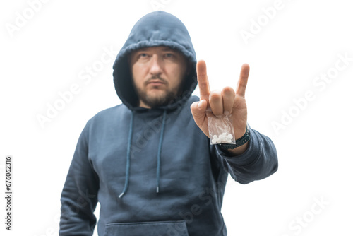 Criminal man in a hood holds transparent plastic bag with pills hard drugs isolated on white background, drug dealer or gangster sells narcotics