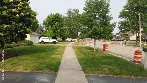 Road Construction Flagger Placing Traffic Cones Along Road photo