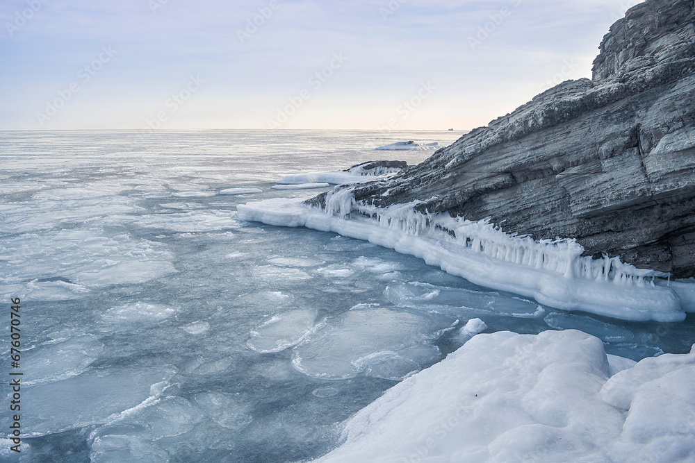 Obraz premium Sea winter landscape. Sea slush and ice floes on the sea surface in winter during sunset. Fabulous winter day by the sea.