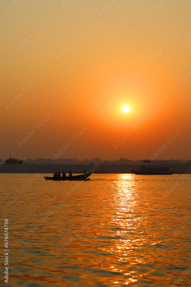 The sun rises over the eastern riverbank of the Ganges River near Varanasi India.