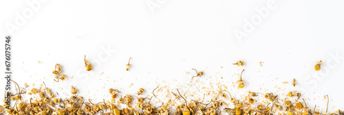 Dried camomile flowers on white table with copyspace