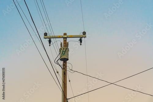 Power electric pole line against sky at sunset