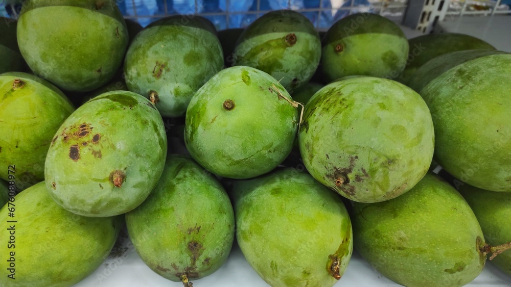 Pile of green mango displayed in supermarket to attract the buyer Pile of green mango displayed in supermarket to attract the buyer