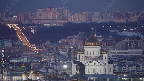 The famous symbol of Moscow, the Cathedral of Christ the Saviour, at night against the background of the cityscape. The famous establishing plan of the Cathedral of Christ the Saviour