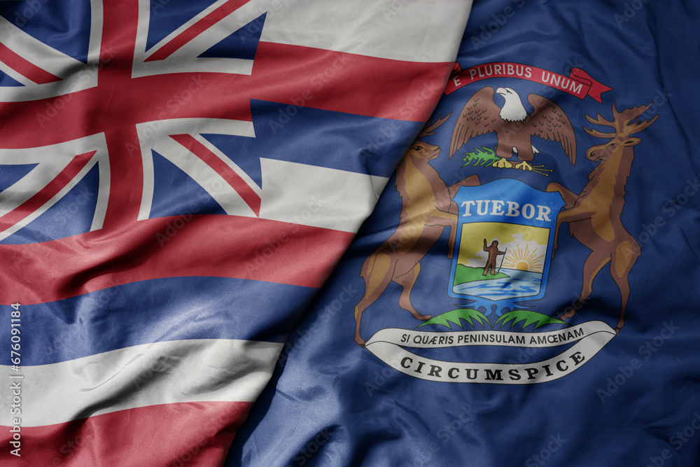 Fototapeta premium big waving colorful national flag of michigan state and flag of hawaii state .